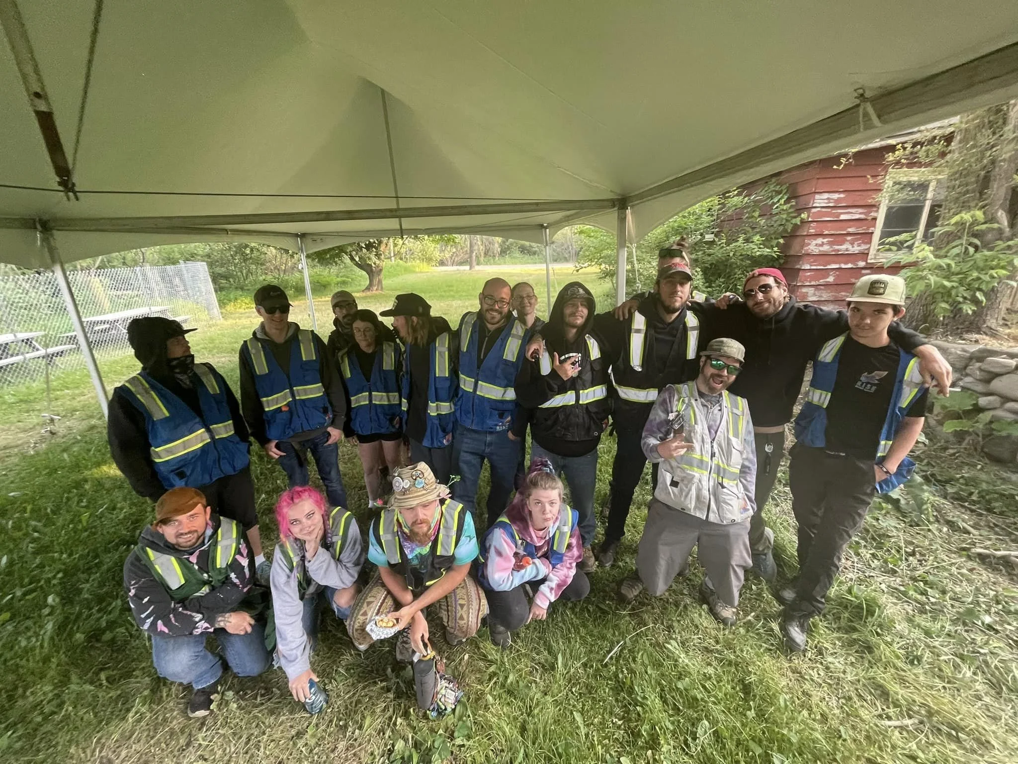 Group wearing reflective vests under tent outdoors