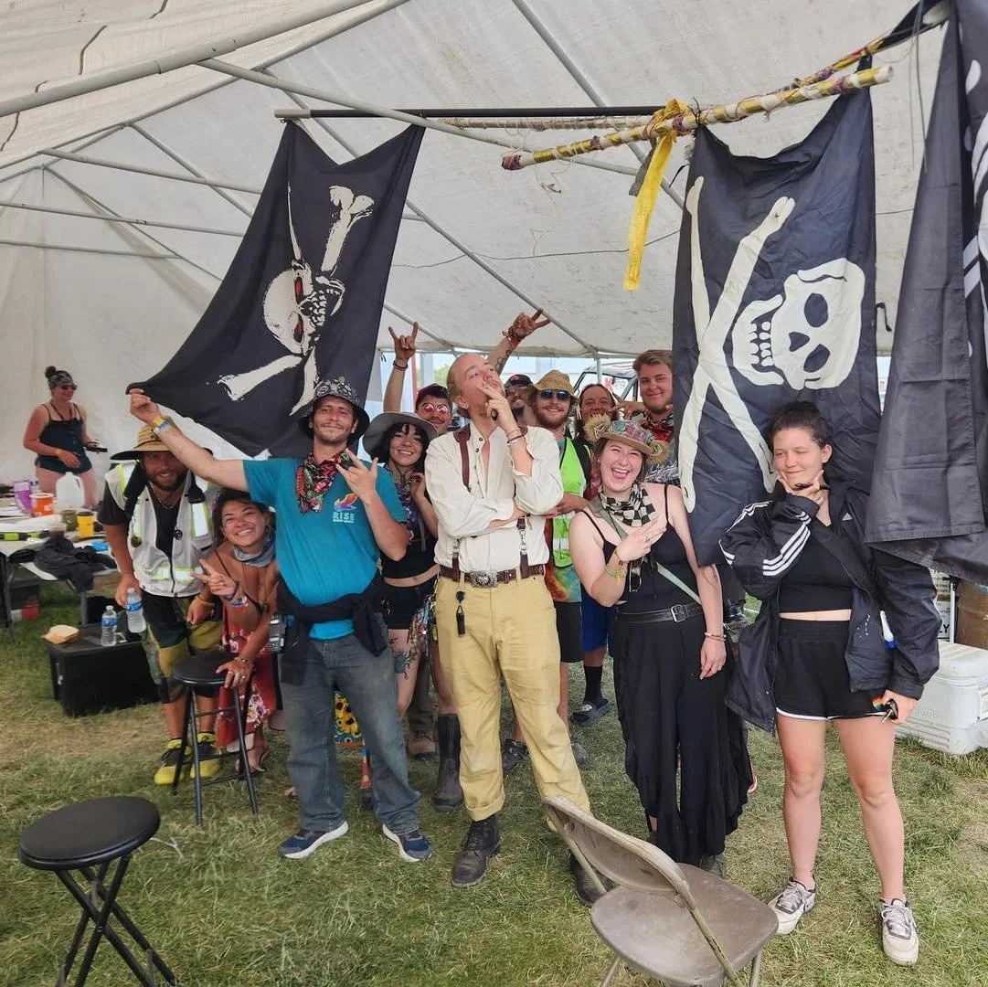 Group celebrating under tent with pirate flags