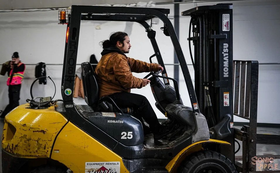 Man operating a yellow Komatsu forklift