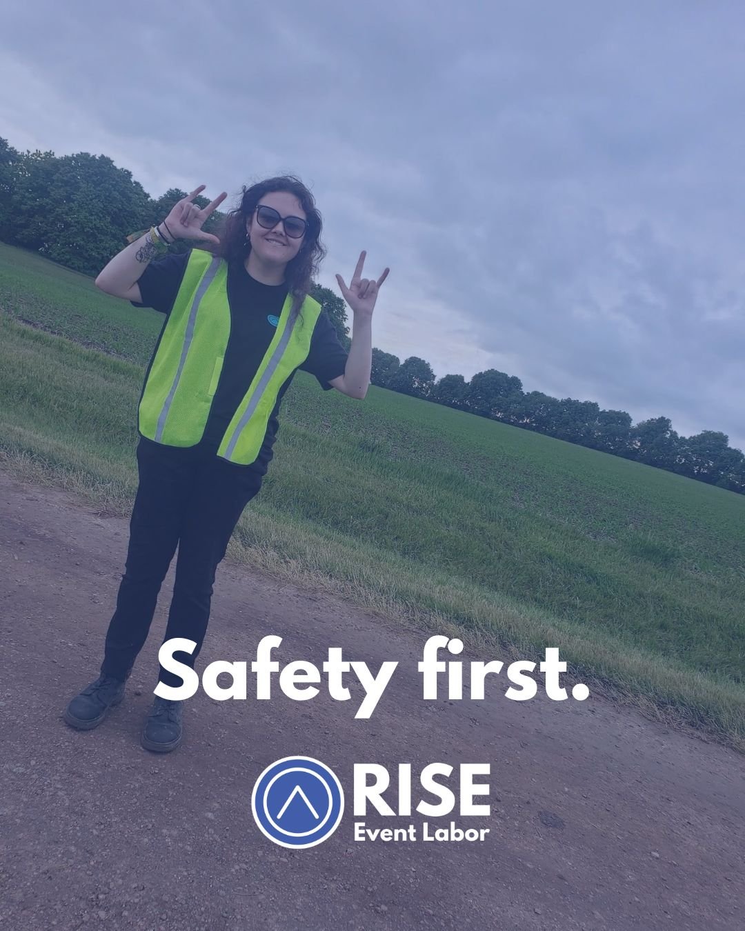 Woman in yellow safety vest making rock hand gestures outdoors