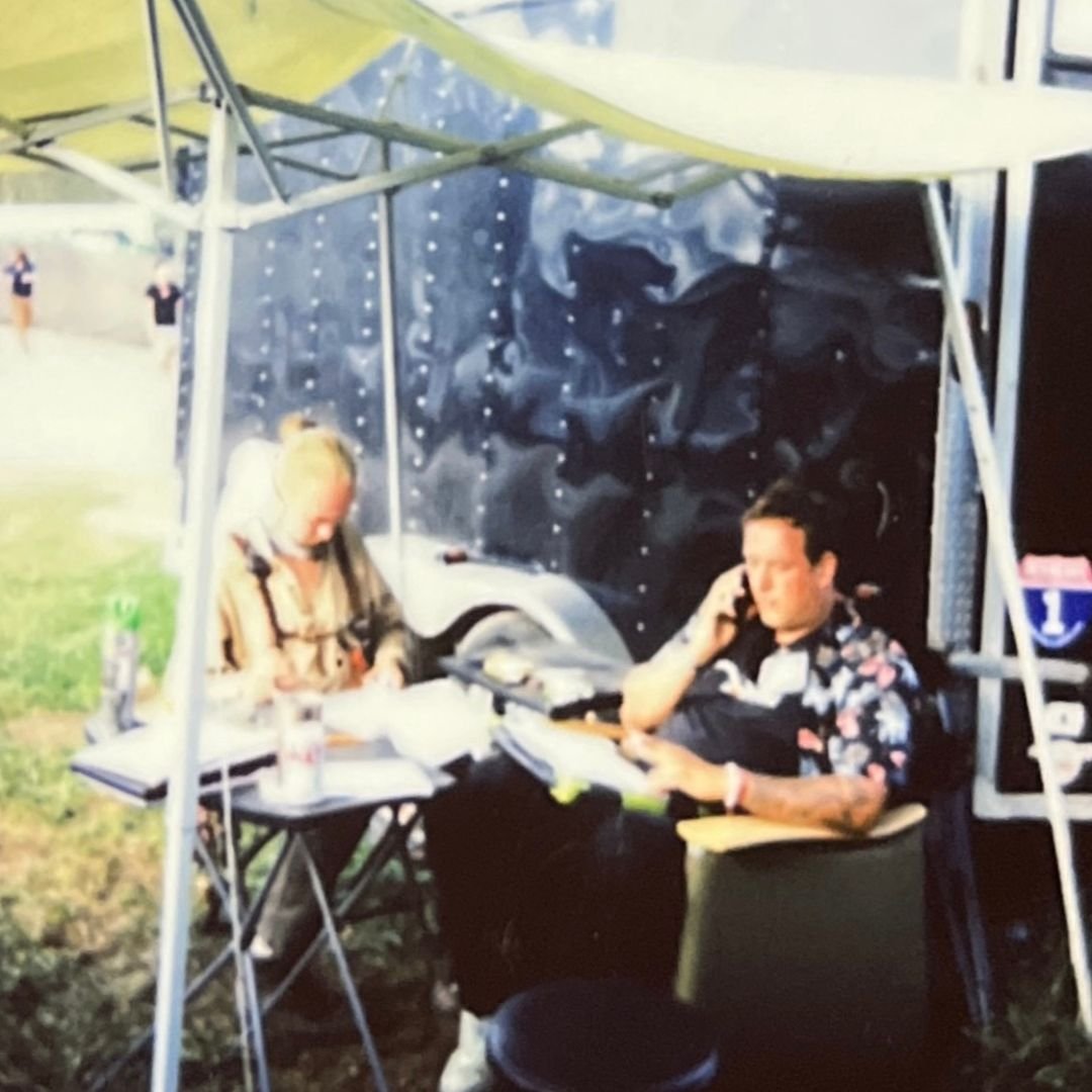 Two men at a registration table at an outdoor event