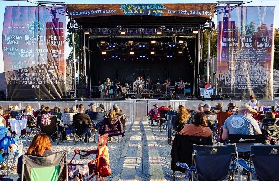 Outdoor stage concert with daytime crowd